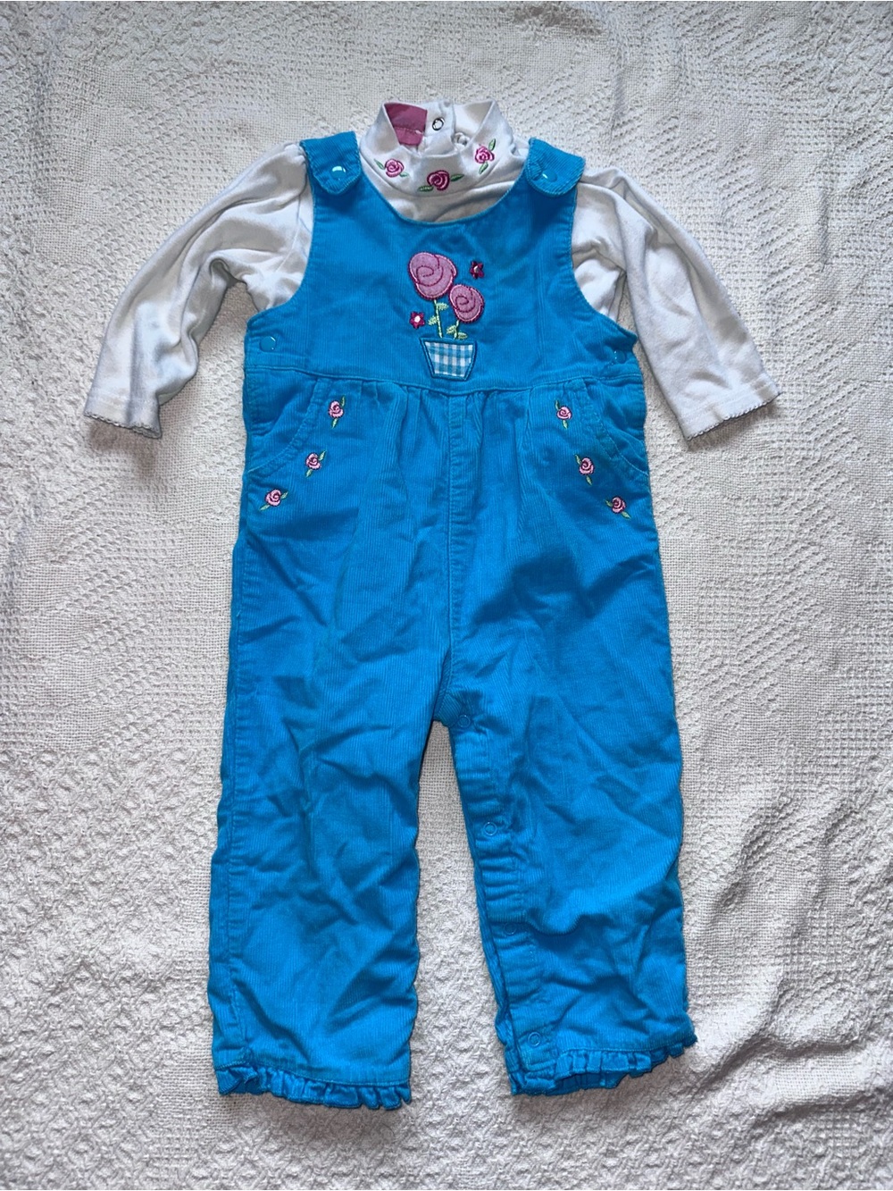 Y2K blue overalls with white undershirt, pink floral design